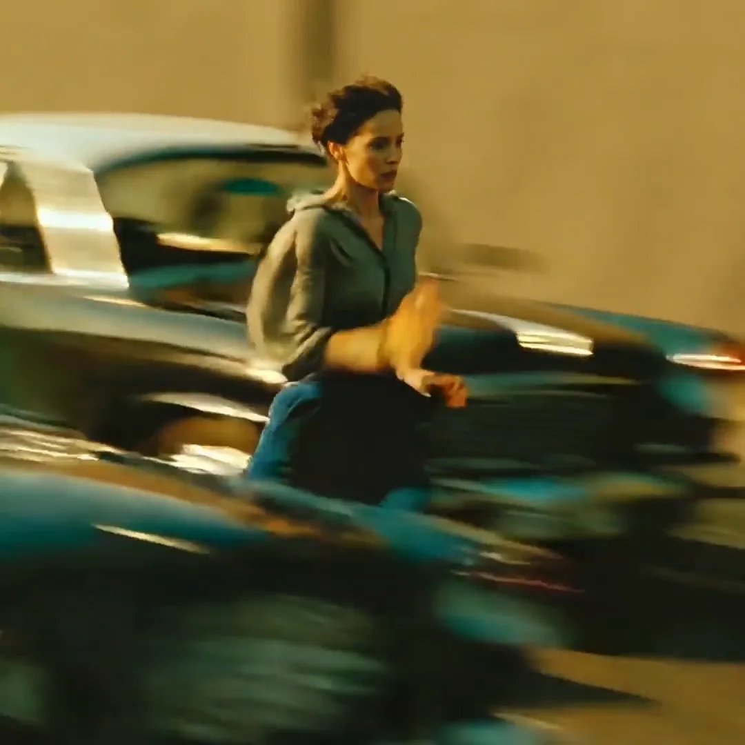 Woman running beside a motion-blurred car in a cinematic tracking shot